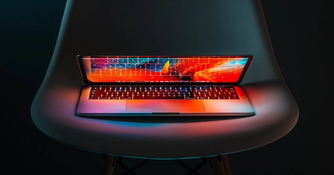 Laptop on a chair with a colorful desktop, vibe coding workspace